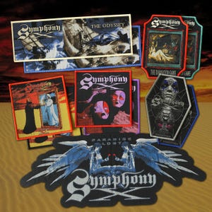 May include: A collection of embroidered fabric patches featuring Symphony X band artwork. Designs include The Odyssey, The Damnation Game, Underworld, and Paradise Lost, with various rectangular, shield, and custom shapes in vibrant colors.