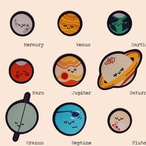 May include: Nine embroidered planet patches, each with a smiling face. Planets include Mercury, Venus, Earth, Mars, Jupiter, Saturn, Uranus, Neptune, and Pluto. Each patch has a black border and is on a light beige background.