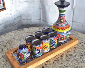Puede incluir: Un juego de cerámica mexicana Talavera de colores incluye una jarra, seis vasos de chupito y un salero, todo en una bandeja de madera.