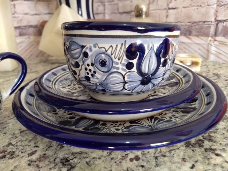 May include: A set of three blue and white ceramic dishes with a floral pattern. The dishes are nested together, with the largest dish on the bottom and the smallest dish on top. The dishes are decorated with a blue and white floral pattern.