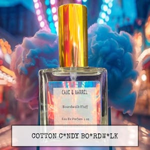 May include: A perfume bottle with a gold cap and a clear glass body. The label reads "CAKE & BARREL Boardwalk Fluff Eau De Parfum 1 oz." Fluffy blue and pink cotton candy is in the background. The text "COTTON C*NDY BO*RDW*LK" is at the bottom.