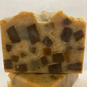 May include: Two bars of handmade soap with a brown and beige swirl pattern. The soap is made with natural ingredients and is perfect for sensitive skin.
