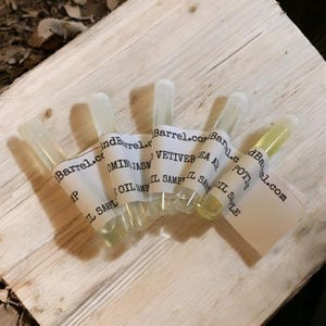 May include: Five small glass bottles with labels that say "Barrel.com" and the names of different essential oils: "Ominjasm", "Vetiver", "Sea Amber", "Potti", and "IP".