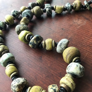 Antique granite & wound glass from Hebron, brass on knotted black leather.