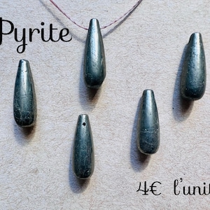 May include: Five elongated, teardrop-shaped pyrite pendants. The pendants are a metallic gray-green color and appear to be polished. The word "Pyrite" is written in a cursive font at the top of the image.