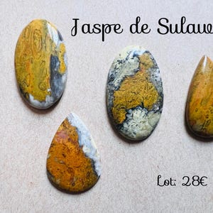 Puede incluir: Cuatro piedras pulidas de jaspe de Sulawesi en tonos amarillos, naranjas, grises y blancos. Las piedras son ovaladas y en forma de lágrima, con el texto "Jaspe de Sulawesi" en escritura negra.