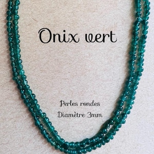 Puede incluir: Un collar de cuentas redondas de ónix verde, con el texto "Onix wert" y "Perles rondes Diamètre 3mm" sobre un fondo marrón.