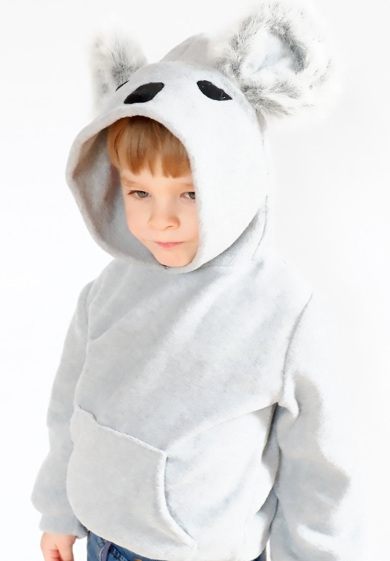 Op de afbeelding: Een lichtgrijs hoodie met een koala-gezicht op de capuchon. De capuchon heeft pluche oren. De hoodie heeft een kangoeroezak.