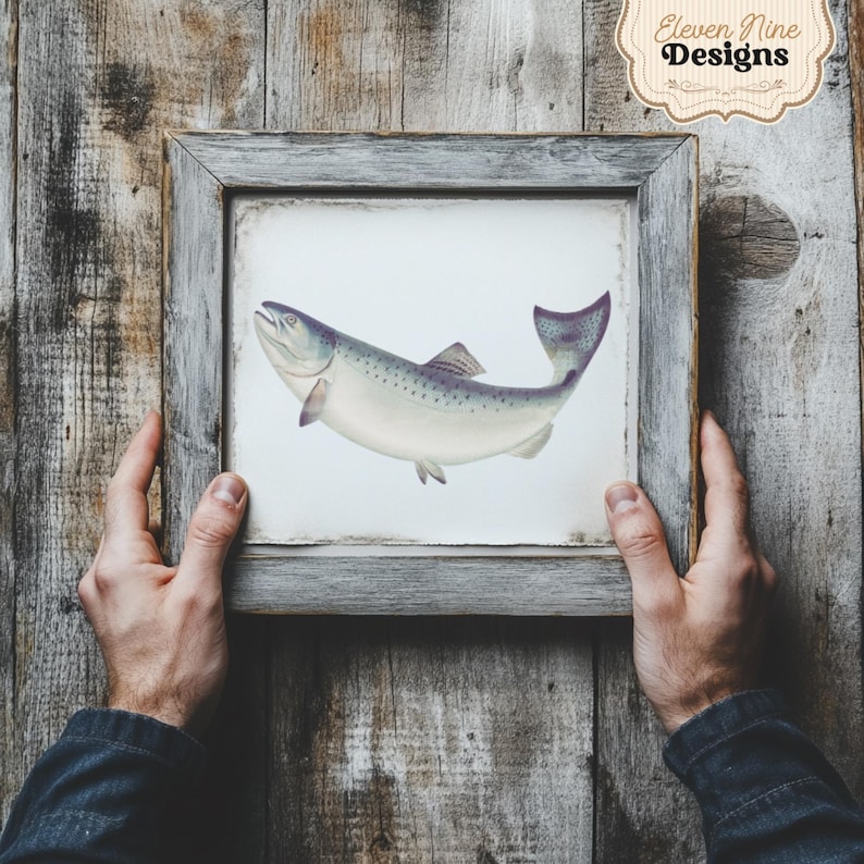May include: A framed print of a realistic illustration of a silver and grey fish with a black outline. The fish is swimming to the right. The frame is a light grey wood with a white mat.