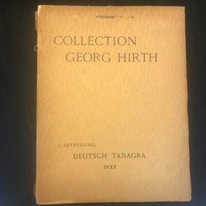 May include: A vintage book cover with the title "COLLECTION GEORG HIRTH" in dark grey lettering. The cover is a light tan colour with a textured surface. The text "I. ABTEILUNG: DEUTSCH TANAGRA TEXT" is also visible.