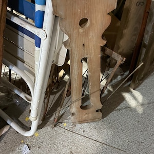 May include: A close-up of a wooden decorative piece with a unique design. The piece is made of light brown wood and has a carved pattern. It is sitting on a gray surface.