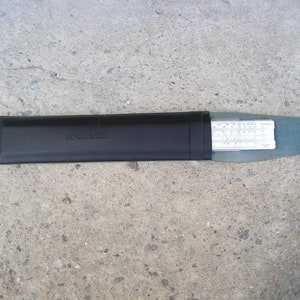 Może przedstawiać: Czarne skórzane etui z wytłoczonym napisem "LOGITECH". Wewnątrz etui znajduje się srebrna suwmiarka.