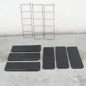 Puede incluir: Cinco estantes de metal negro con un marco de metal negro. Los estantes est&aacute;n vac&iacute;os y listos para ser utilizados para almacenamiento o exhibici&oacute;n.