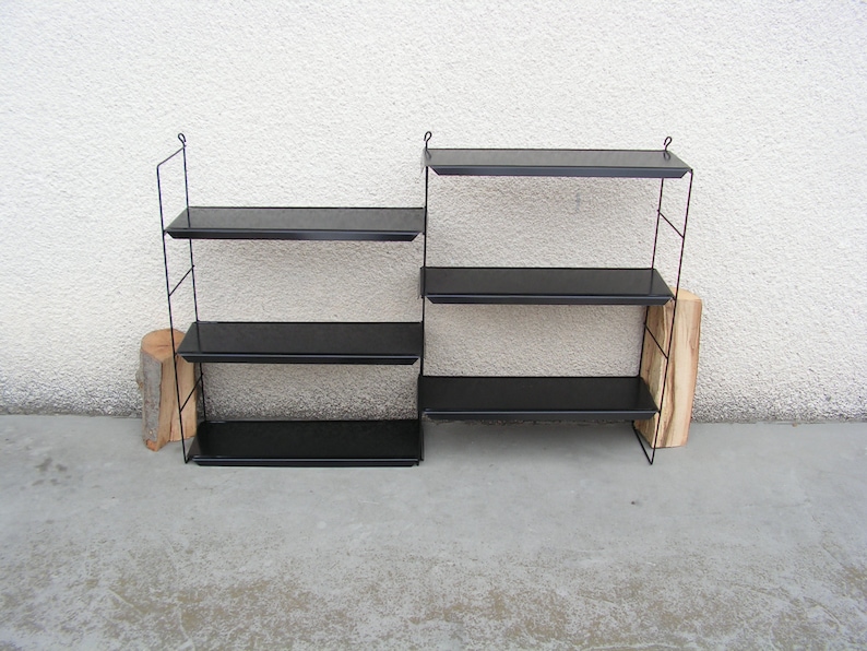 Puede incluir: Dos unidades de estanter&iacute;a de metal negro con cuatro estantes cada una. Los estantes est&aacute;n hechos de metal negro y tienen un dise&ntilde;o simple y moderno.