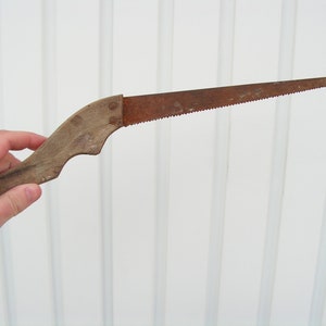 Antique saw wooden handle Rusty saw Primitive cutting tool Carpentry tool Sawing wood Working tool cutting wood Old hand saw for collection