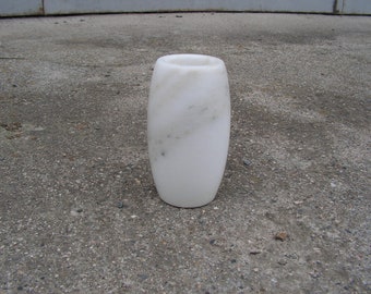 May include: A white marble vase with a smooth, rounded shape. The vase has a subtle marbled pattern throughout.