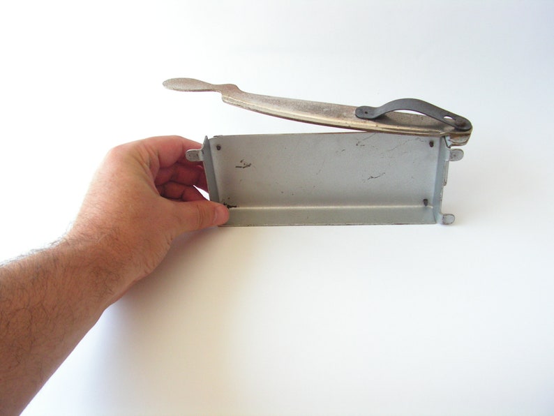 May include: A vintage metal food cutter with a silver finish and a black handle. The cutter is open and ready to use.
