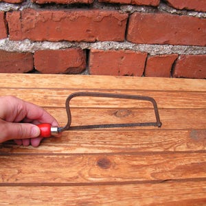 Vintage small saw for wood Metal saw with red handle Carpentry tool Sawing wood Working tool cutting wood Old hand saw for collection