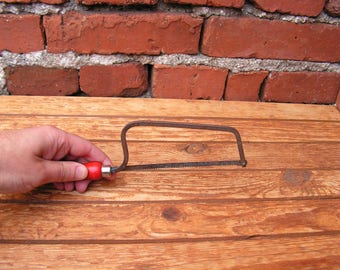 Vintage small saw for wood Metal saw with red handle Carpentry tool Sawing wood Working tool cutting wood Old hand saw for collection