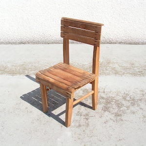 May include: A simple wooden chair with a slatted back and seat. The chair is made of natural wood and has a rustic look.