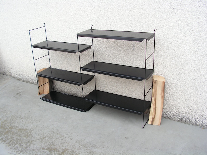 Puede incluir: Una estanter&iacute;a de pared de metal negro con cuatro estantes. Los estantes est&aacute;n hechos de metal negro y tienen un dise&ntilde;o simple y moderno.