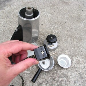 May include: A silver and black electric coffee maker with a detachable cord and plug. The coffee maker is disassembled, showing the internal components.