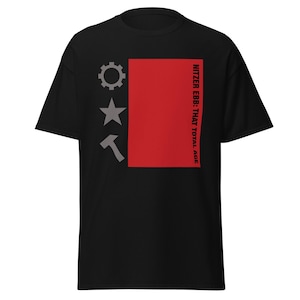 Könnte beinhalten: Schwarzes T-Shirt mit rotem Rechteck und dem Text "Nitzer Ebb: That Total Age". Auf der linken Seite befinden sich ein Zahnrad, ein Stern und ein Hammer in Grau.