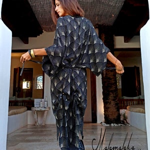 May include: A black kimono-style robe with a fan-shaped gold and white pattern. The robe is tied at the waist with a matching belt. The text "Malamalaka..." is written in cursive on the bottom right of the image.