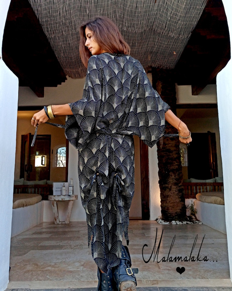 May include: A black kimono-style robe with a fan-shaped gold and white pattern. The robe is tied at the waist with a matching belt. The text "Malamalaka..." is written in cursive on the bottom right of the image.