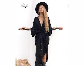 May include: A black button-down midi dress with a V-neckline, wide sleeves, and a matching tie belt at the waist. The garment features a front button closure and two side pockets. The text "Makemake.." with a heart symbol is visible in the top left corner.