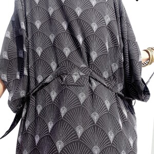 May include: Black kimono-style robe with a white fan-shaped pattern. The robe has a tie belt and wide sleeves. The text "Mahamalaka..." is visible in the upper right corner. The robe is made of a soft, flowing fabric.