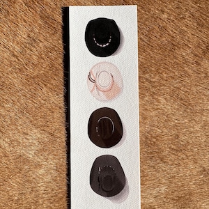 May include: Four different cowboy hats in a row on a white background. The hats are black, beige, brown, and gray.