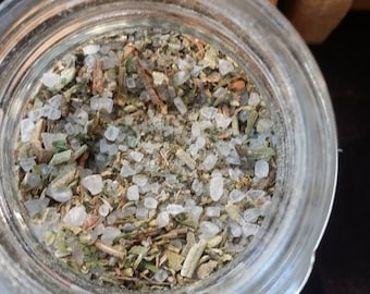 May include: A glass jar filled with a mixture of dried herbs and white salt crystals.