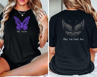 May include: Black t-shirt with a purple butterfly graphic on the front and a gray butterfly graphic on the back. The front graphic says "What You See" and the back graphic says "What You Don't See".