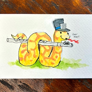 May include: Watercolor illustration of a yellow snake playing a flute, wearing a top hat. The snake has orange markings and is on a green grassy area. Text reads "Foot Poot!" in red.