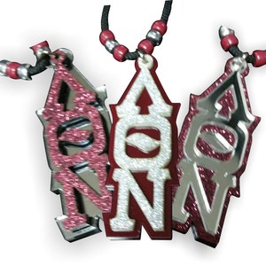May include: Three silver and red glitter necklaces with the letters "AON" on each pendant.
