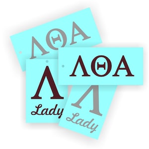 May include: Four blue paper tags with the letters "ΛΘΑ" and the word "Lady" printed on them. The letters are in a dark maroon colour and the word "Lady" is in a grey colour.