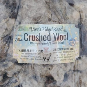 May include: A bag of crushed wool from River's Edge Ranch. The label states the net weight is 3 lbs. and the product is 100% regeneratively raised wool. It is a natural fertilizer that decreases watering by 25% and aerates soil.