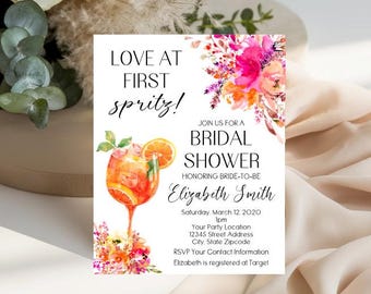 Op de afbeelding: Een rechthoekige uitnodigingskaart voor een bruidsdouche met de tekst Love at First Spritz, een aquarelillustratie van een oranje spritz-cocktail en een levendig bloemstuk in roze, oranje en paarse tinten op een witte achtergrond.