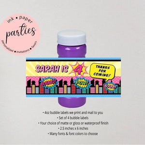 May include: A purple bubble bottle with a rectangular label featuring a comic book city skyline, yellow sunbursts, and the text SARAH IS 4, BANG, POW, BAM, and THANKS FOR COMING. The label measures 2.5 inches by 6 inches for a 4oz bubble bottle.