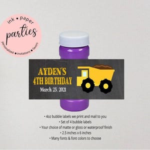 May include: A purple bubble bottle with a white cap featuring a rectangular label. The label has a dark gray chalkboard background with yellow text reading AYDEN'S 4TH BIRTHDAY March 23, 2021 and a yellow dump truck graphic with black wheels.