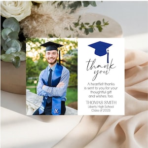 May include: A graduation thank you card featuring a photo of a graduate in a cap and gown with a blue stole. The card includes a blue graduation cap icon, the text "thank you", "A heartfelt thanks is sent to you for your thoughtful gift and wishes, too.", "THOMAS SMITH", "Liberty High School", and "Class of 2025".