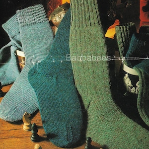 May include: Knee-high knitted socks in teal and green hues. The socks are arranged on a wooden surface, accompanied by chess pieces. The socks are made from a thick yarn, and the image includes the text "4 ply".