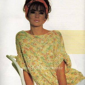 May include: A yellow, green and orange knitted sweater with a loose fit and short sleeves. The sweater is being worn by a person with dark hair and a red headband.