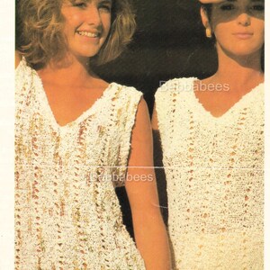 May include: Two women are shown wearing cream-coloured, open-weave V-neck tops. The tops have a textured, lacy appearance. The women are smiling and have their hands near their faces. The image has a vintage aesthetic.