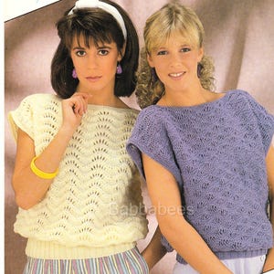 Puede incluir: Dos mujeres con tops de punto con un patrón de encaje. La mujer de la izquierda lleva un top amarillo y la mujer de la derecha lleva un top morado.