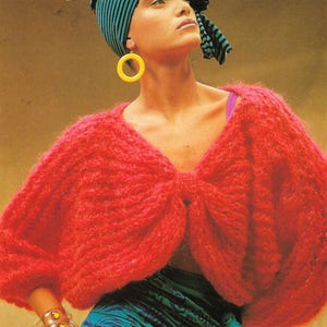 May include: A red knitted sweater with a bow detail at the neckline. The sweater has a loose fit and is made of a soft, fuzzy yarn.