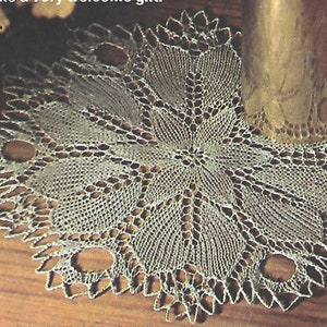 May include: A delicate, white crocheted doily with a floral design and openwork details. The doily is circular and has a diameter of approximately 12 inches.