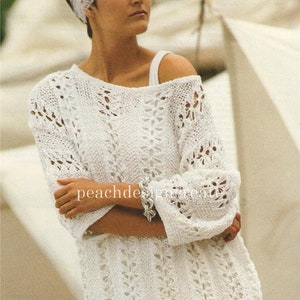 Peut inclure: Pull en crochet blanc à la coupe ample et au motif ajouré délicat. Le pull a un col large et des manches trois-quarts.