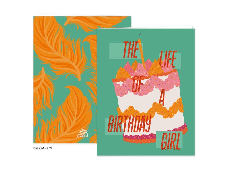 May include: A birthday greeting card with a teal background and a cake illustration. The cake has pink, orange, and white layers with a lit candle. The text reads "THE LIFE OF A BIRTHDAY GIRL." The back of the card has an orange feather pattern.